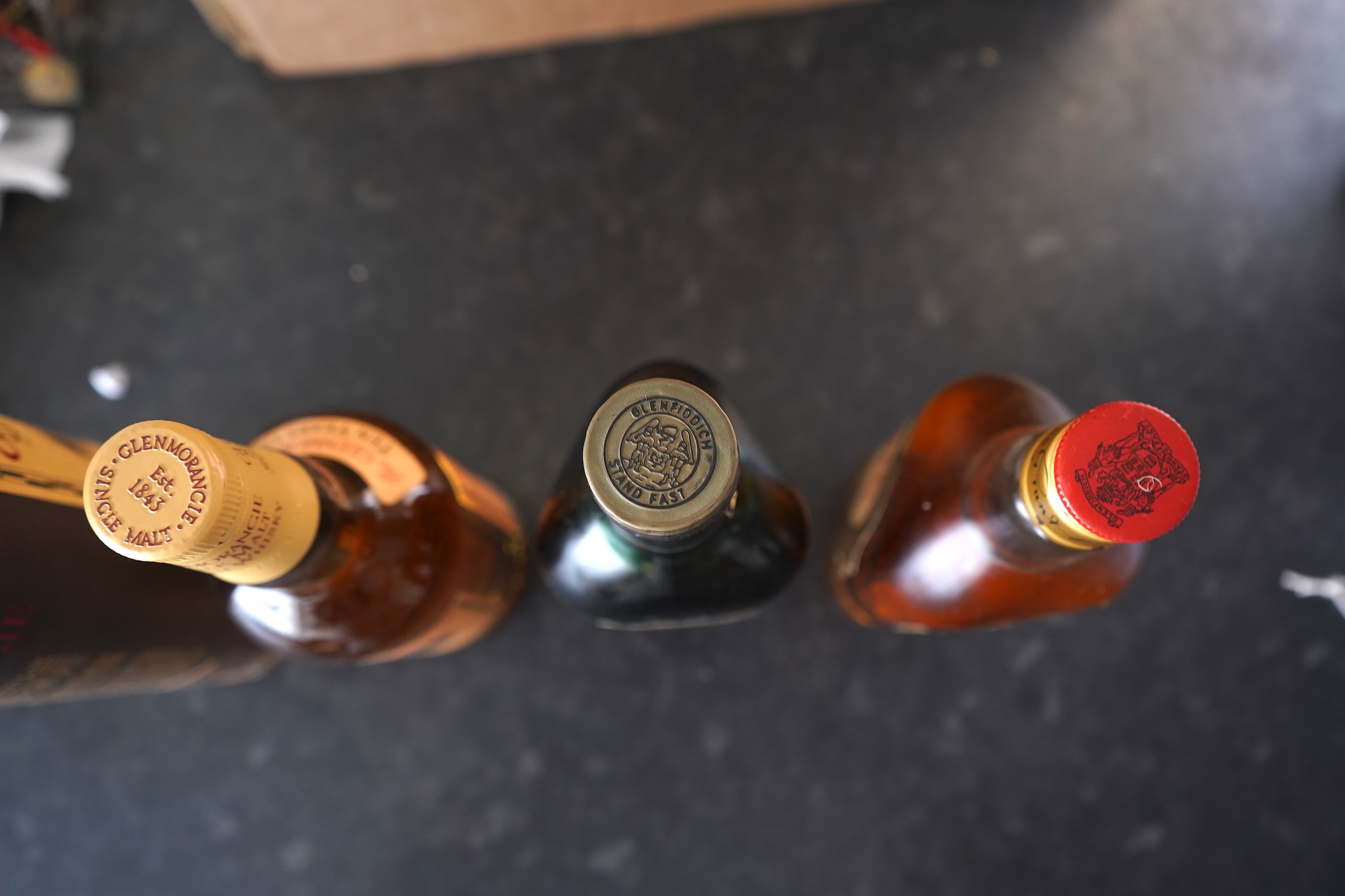 Three bottles of malt whisky: Glenmorangie, Glenfiddich and Grants